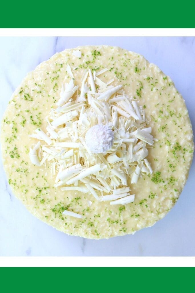 Coconut cheesecake decorated with white chocolate curls and lime zest